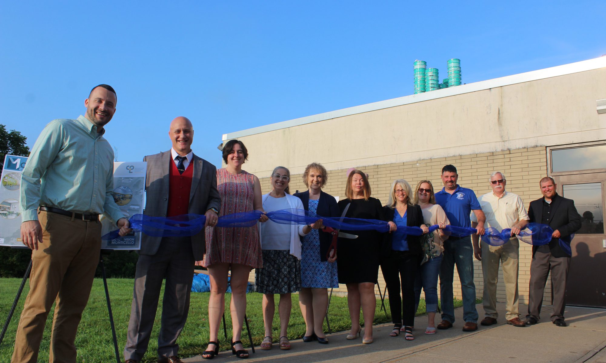 members of the board and representatives from the district's architectural firm cut a ribbon