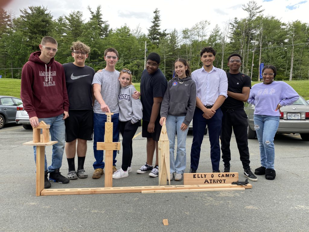 a group of students are posing with the airport structure