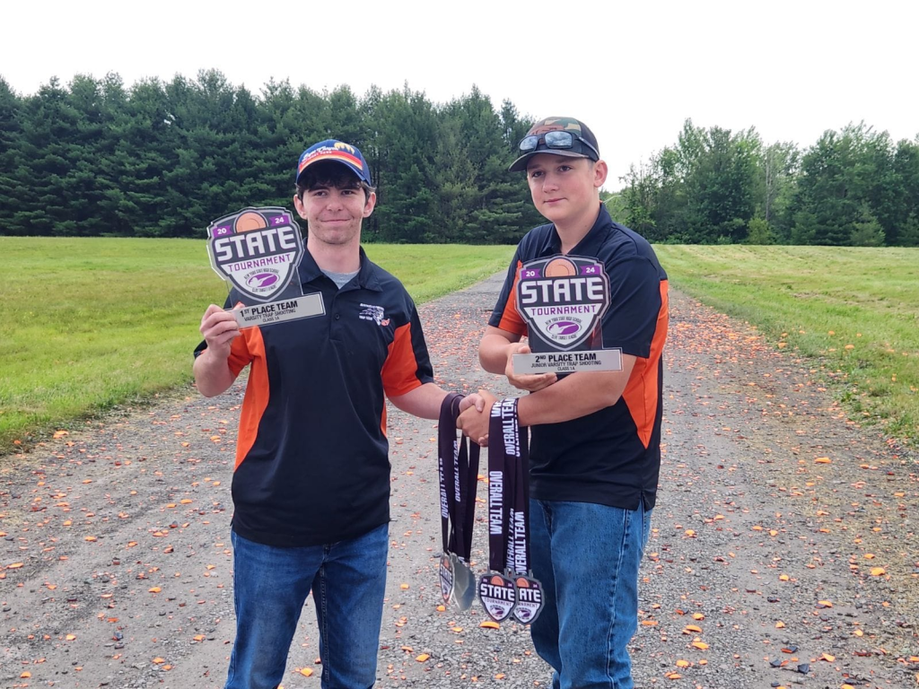 two members of the trap team are holding medals 