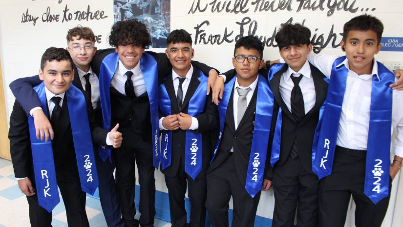 a group of middle school students in tuxedos are smiling