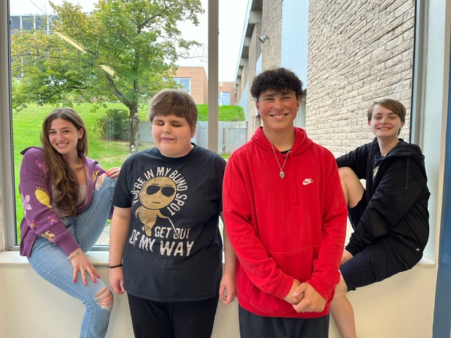 students are posing by a window