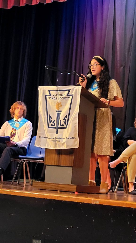 a student is at the podium on stage, speaking. 