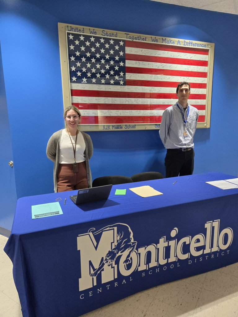 Dr. Brittany Zaccaria, 6th grade School Counselor and Mr. Harrison Larkin, Social  Worker (RJK Staff) are posing behind a table