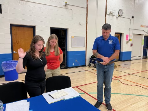 Giada Marone is being sworn in as the board president looks on 