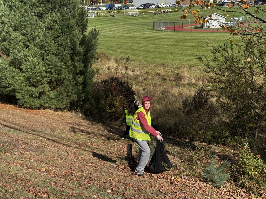 a student is in the distance plucking litter,