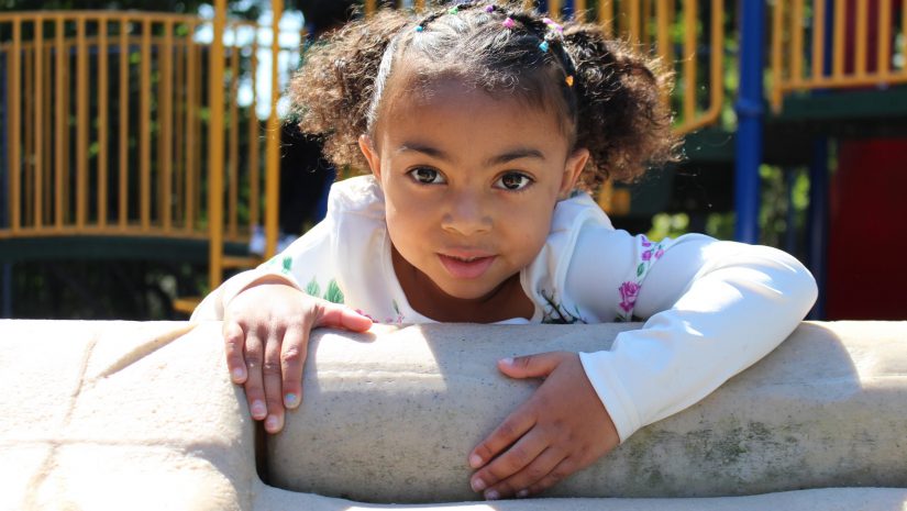 a young girl is playing on playground equipment