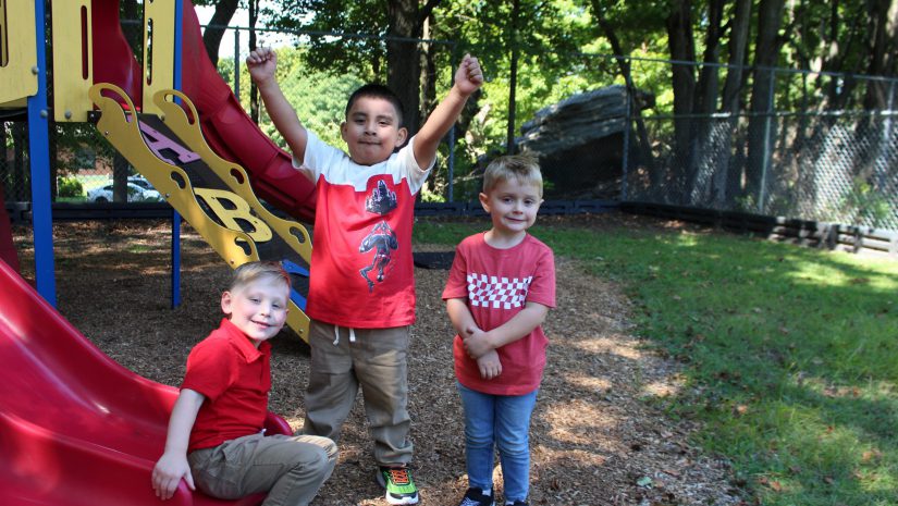 three boys are playing on the playground