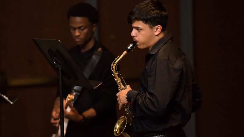 a student is playing a saxaphone during a performance