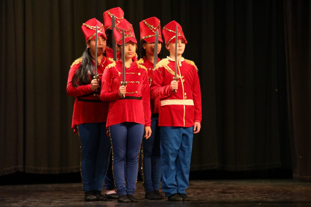 a group of students dressed as soldiers are dancing on stage