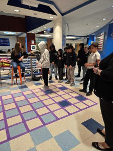 students are guiding each other across a floor.