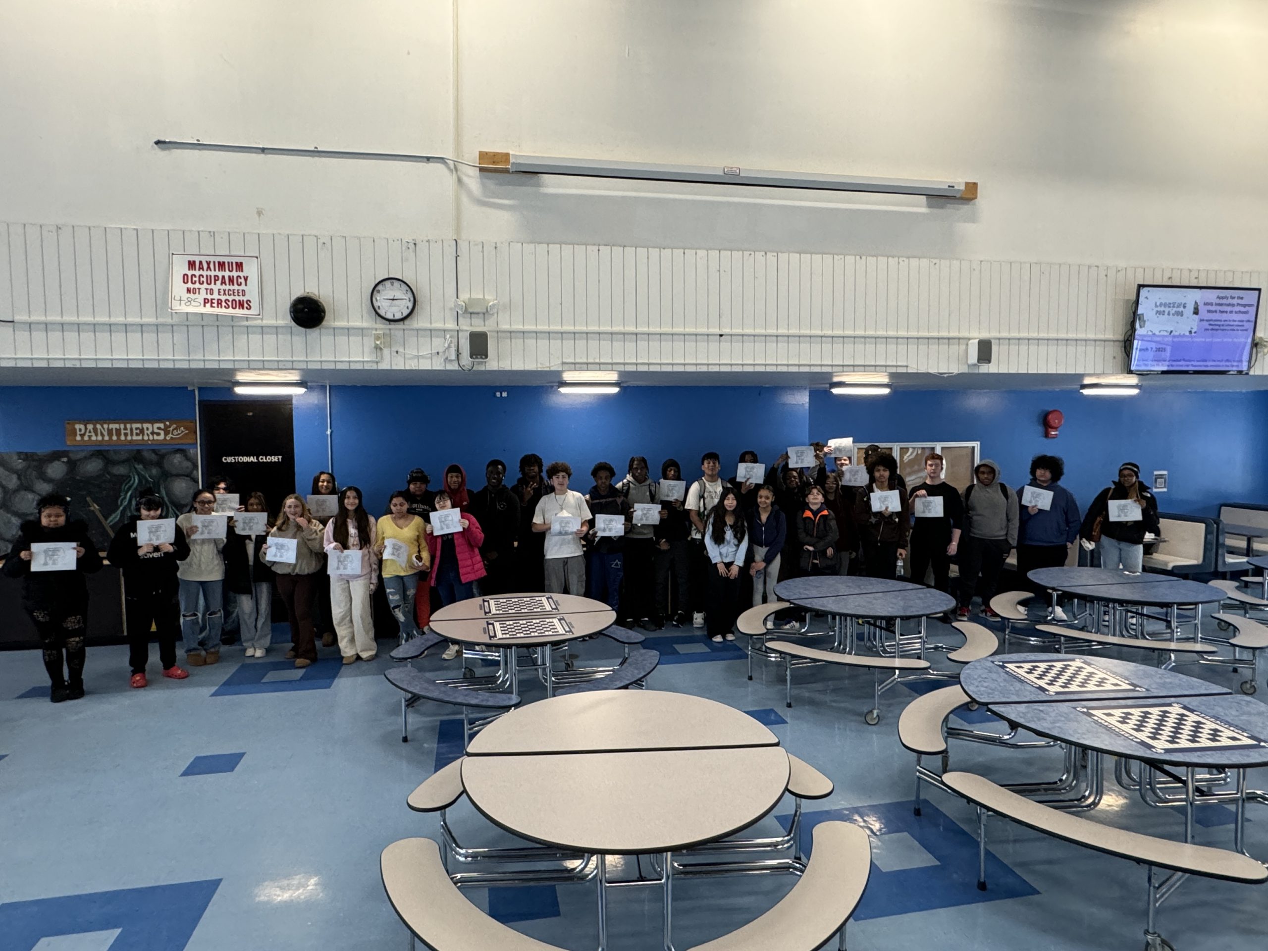 a group of students are posing in the cafeteria