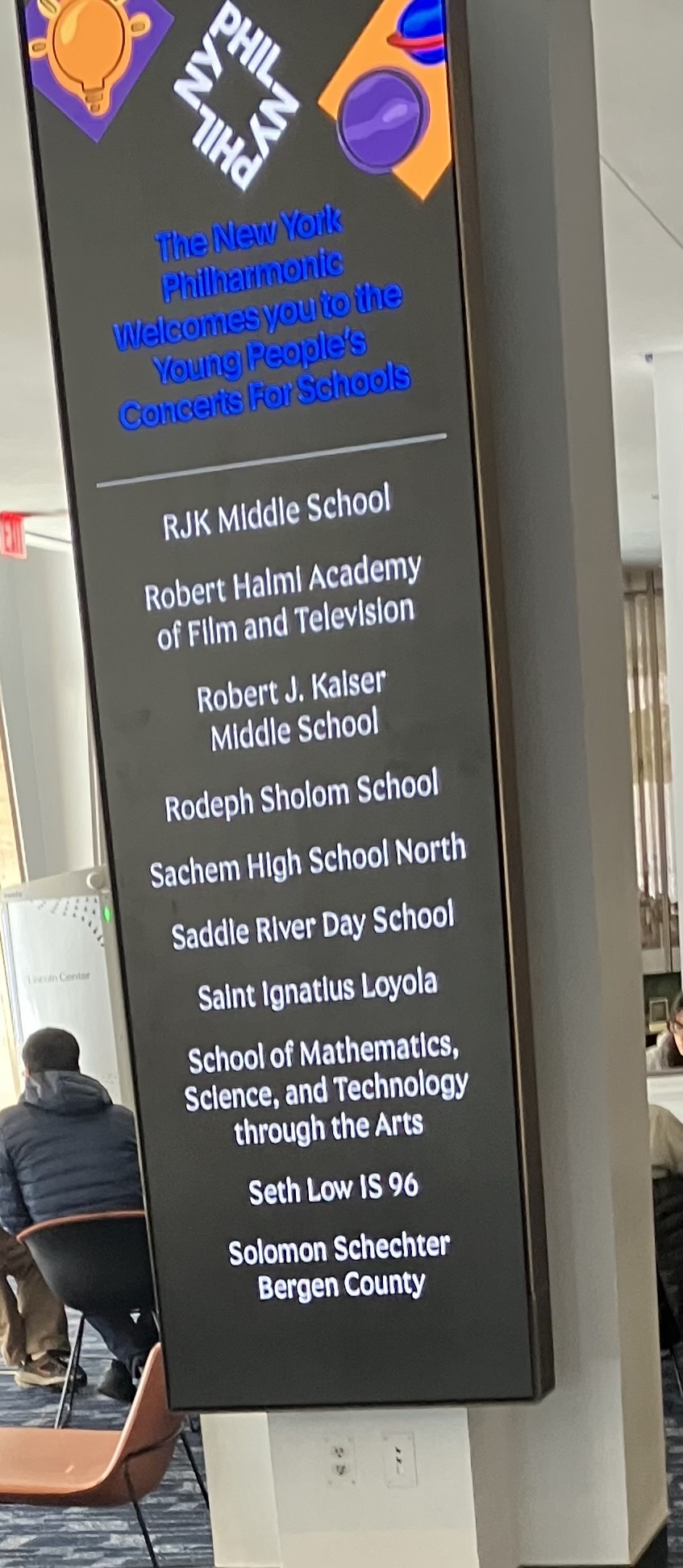 A sign inside of Lincoln Center containing the names of all of the schools who are scheduled to visit