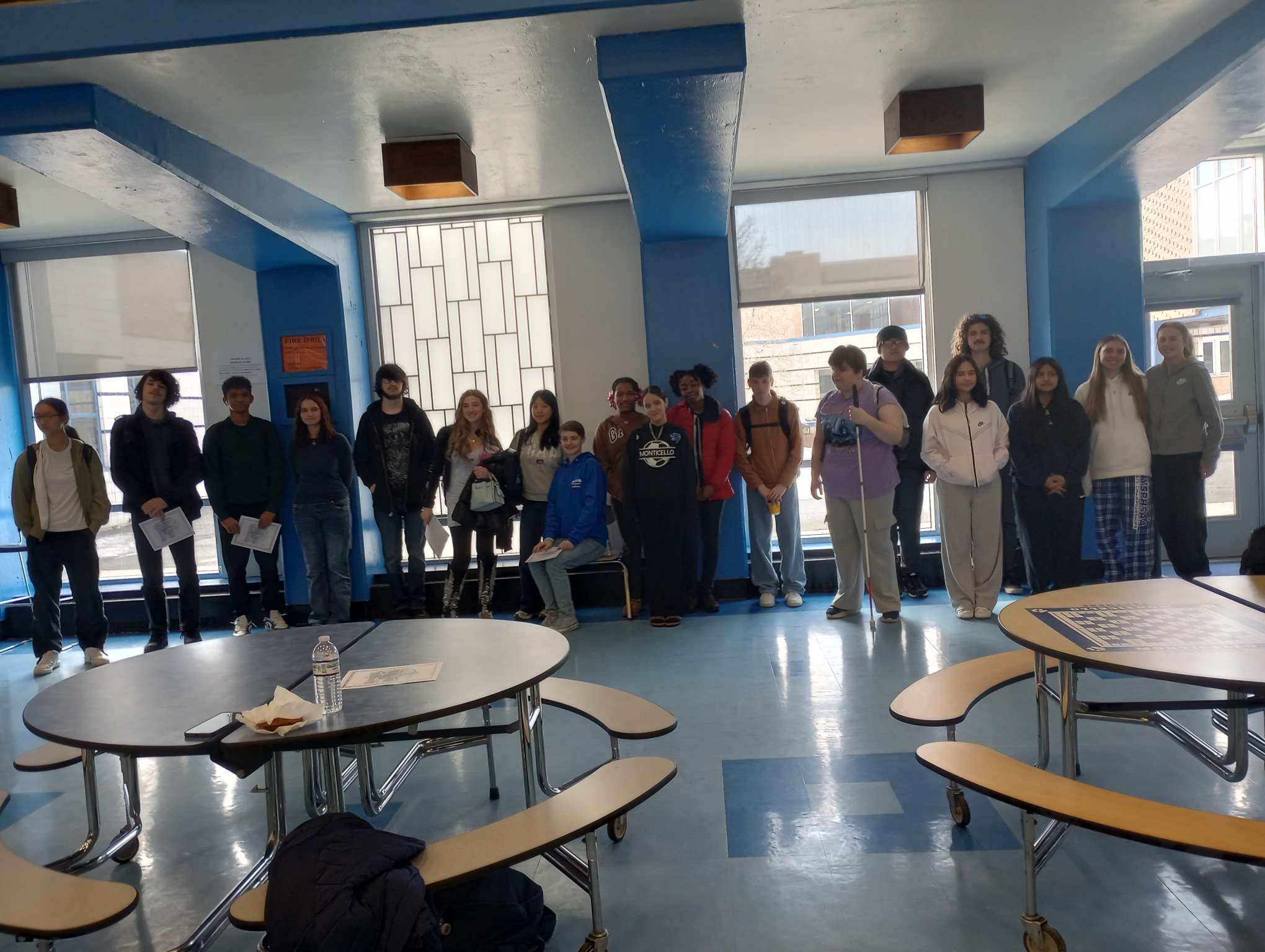 a group of students are posing in the cafeteria