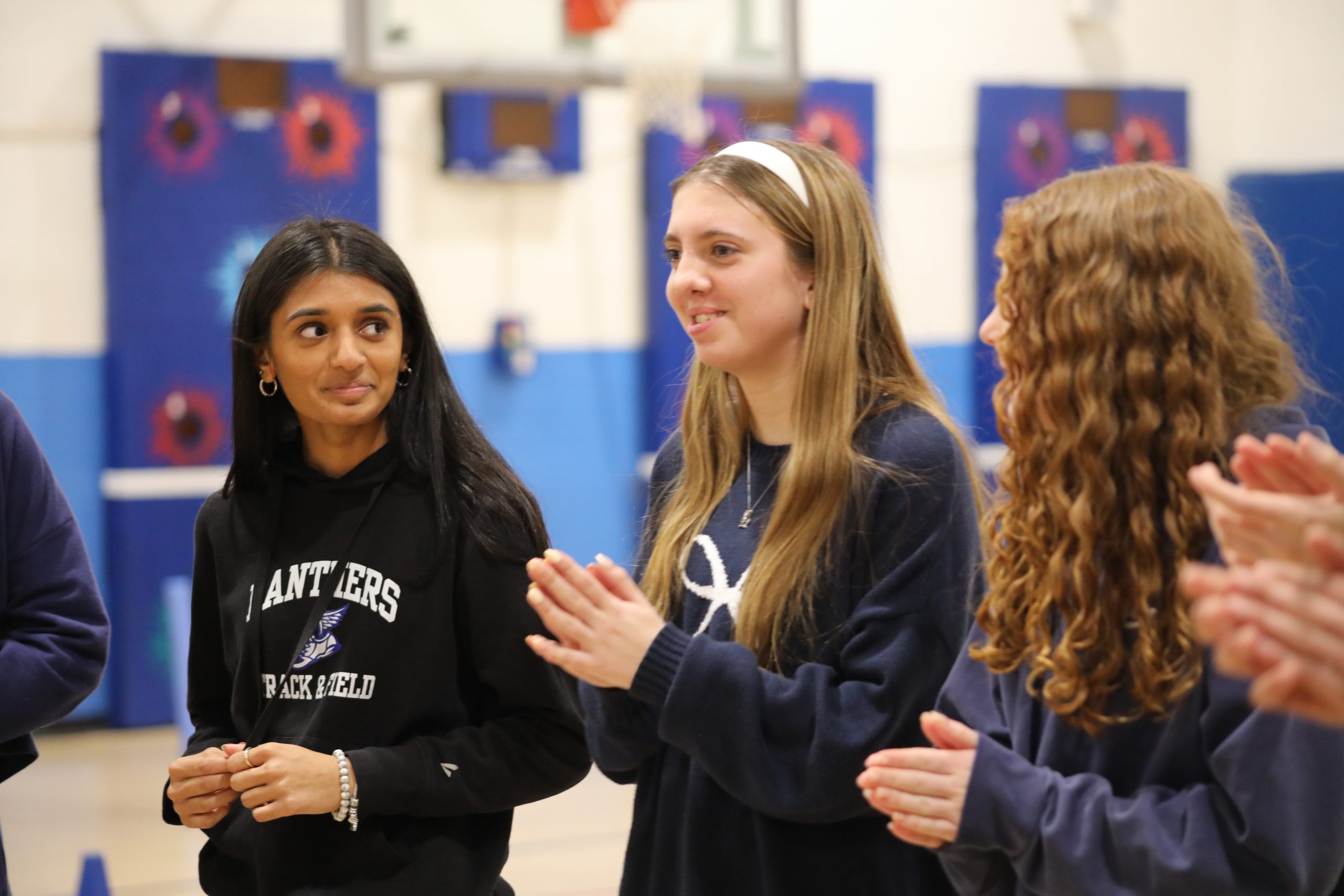 three athletes are speaking to younger students 