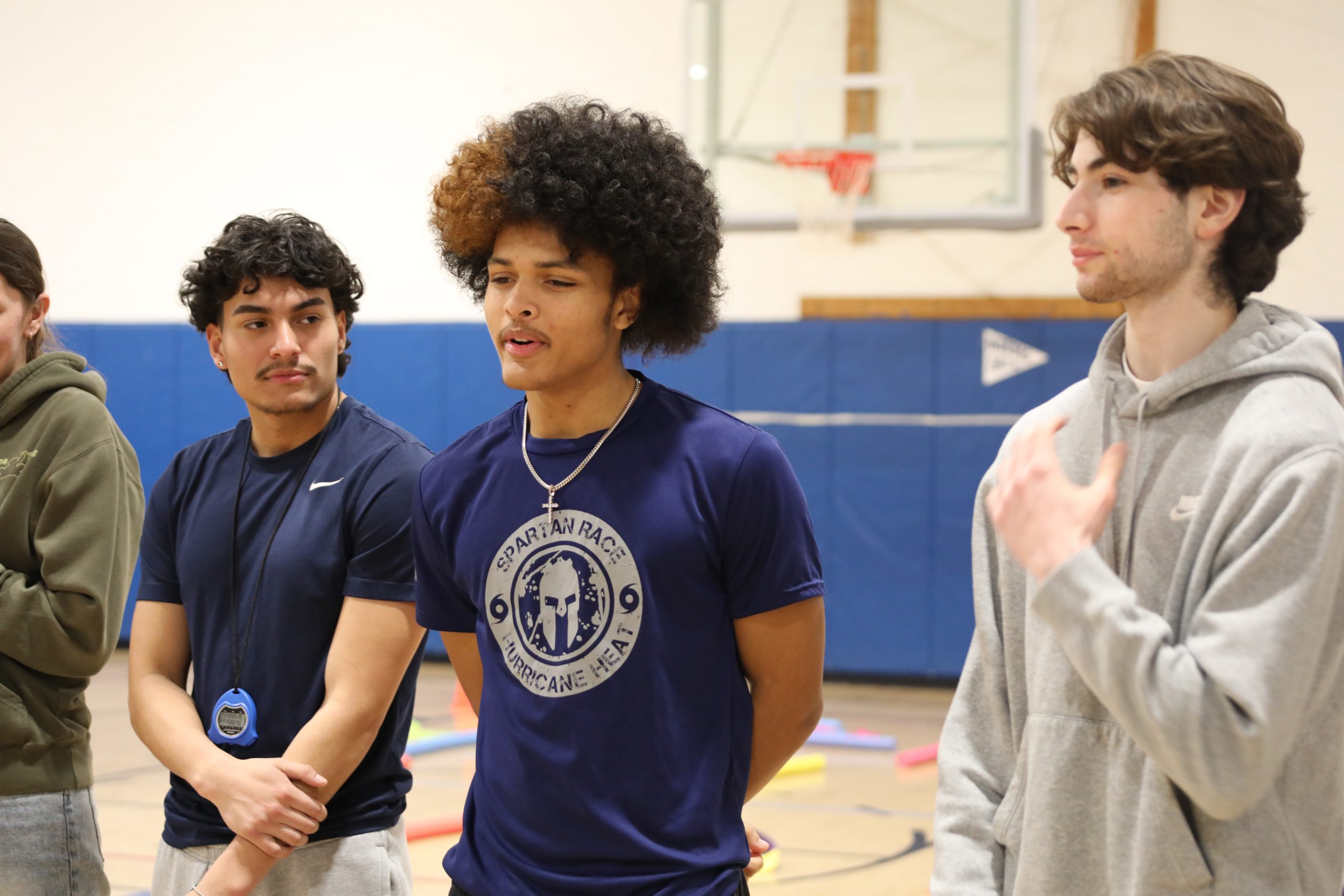 three students are speaking to younger students 