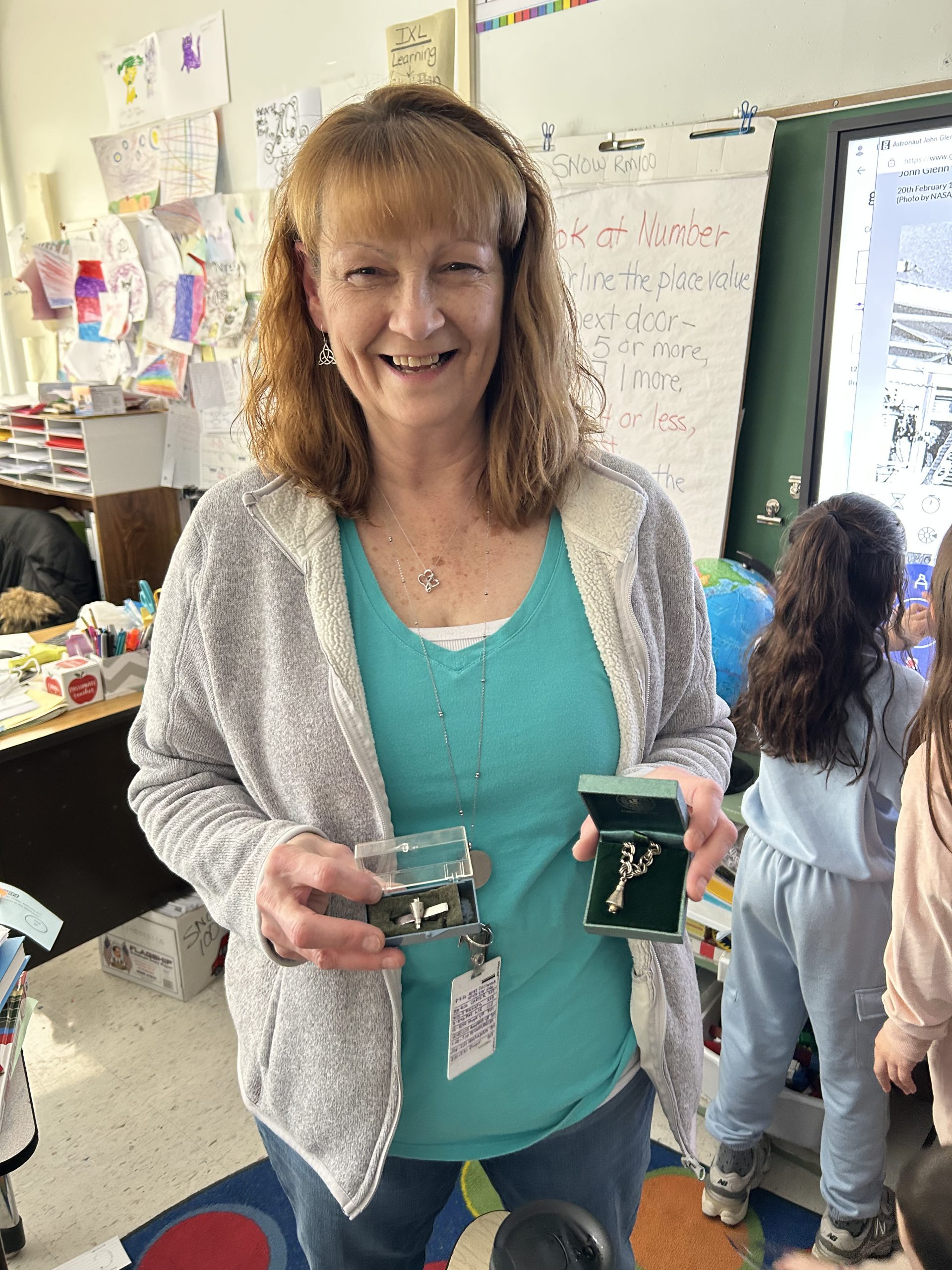 Ms Holland is smiling for the camera and holding some of the tokens 