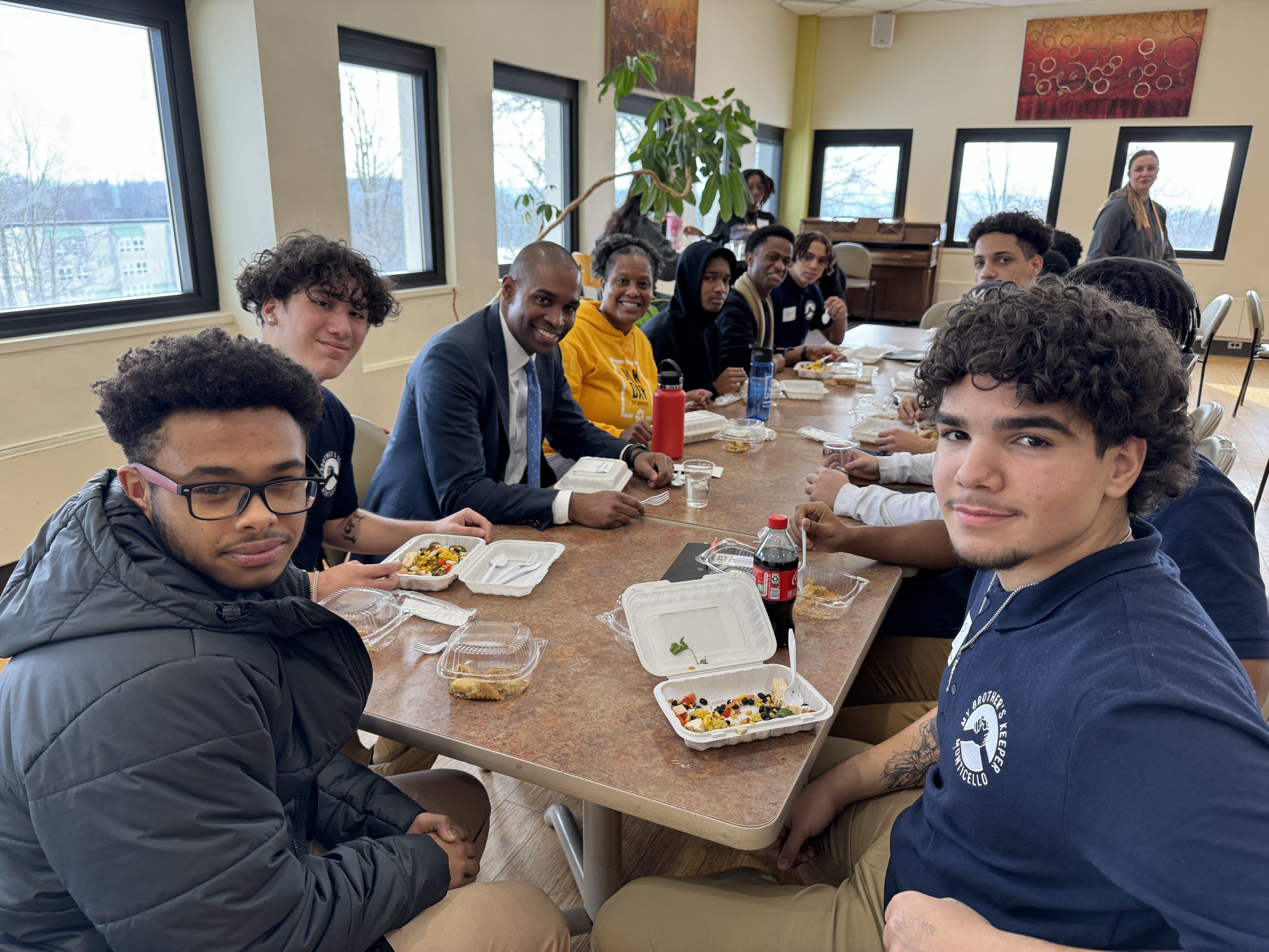 students are seated around a table with the lieutenant governor