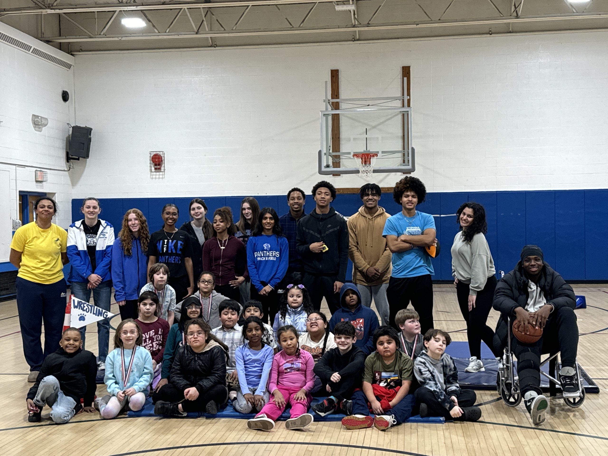 group photo of all high school athletes and elementary students