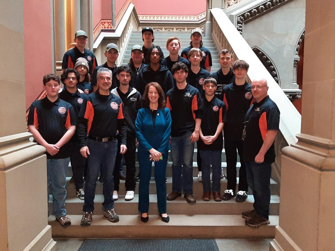 the trap team poses with Paula Kay on the steps of an Albany building 