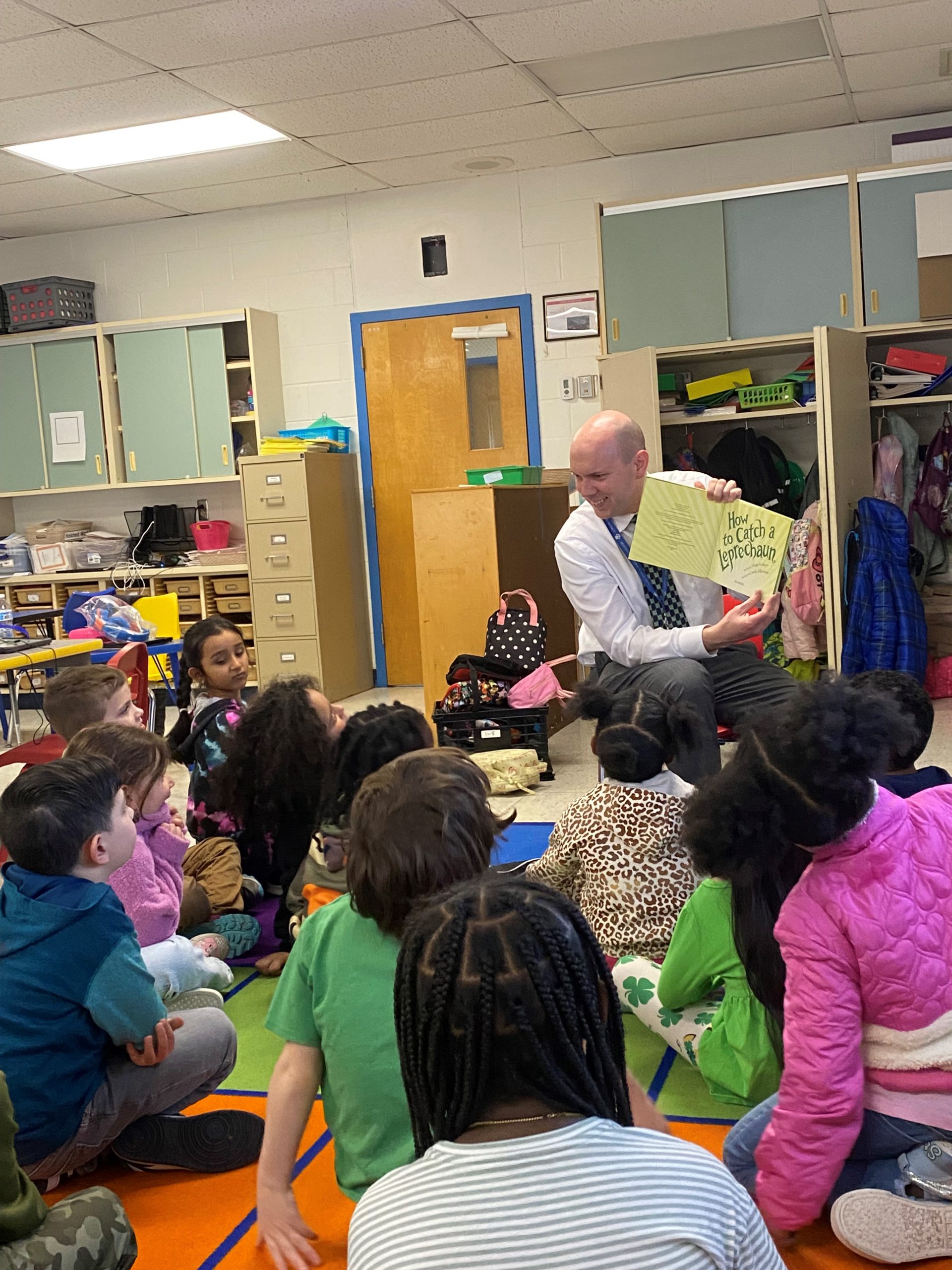 a man is reading aloud to a group of children